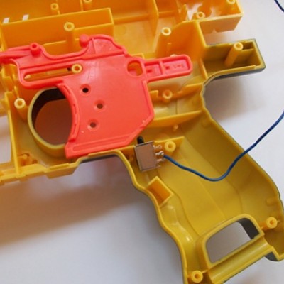 Der Schalter wird in der anderen Hälfte direkt unter dem Abzug platziert, der den Motor dann nur beim Abziehen anschaltet. So ist man das nervige Daue