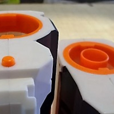 Der Einrastdruckknopf hat einen gerundeten Zylinderkopf im Gegensatz zum Halbkugelkopf der Modulus. Hält je nach Blaster fester lässt sich aber auch s