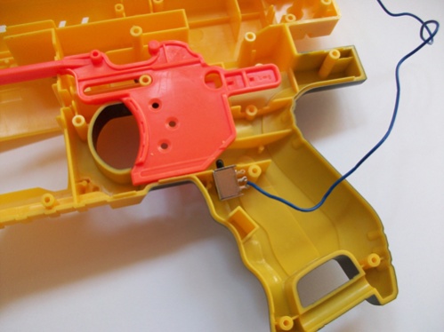 Der Schalter wird in der anderen Hälfte direkt unter dem Abzug platziert, der den Motor dann nur beim Abziehen anschaltet. So ist man das nervige Daue